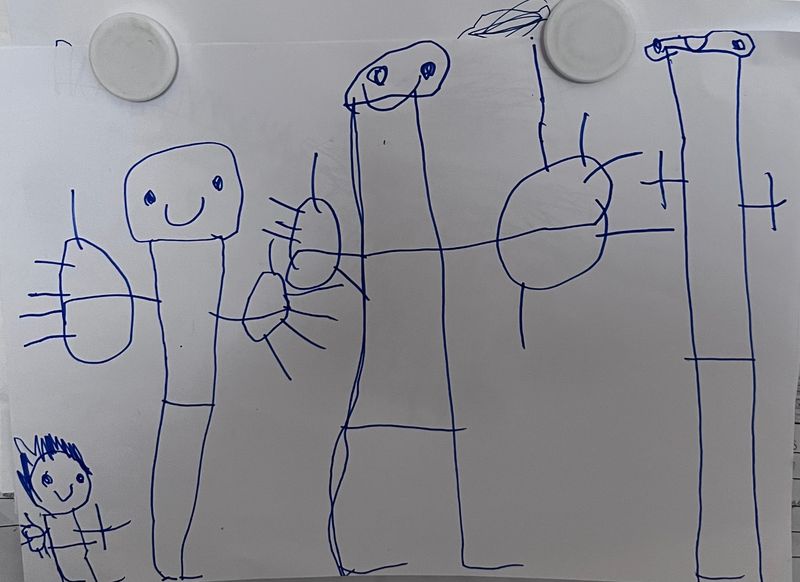 Four stick people drawn in blue felt tip on a sheet of white A4